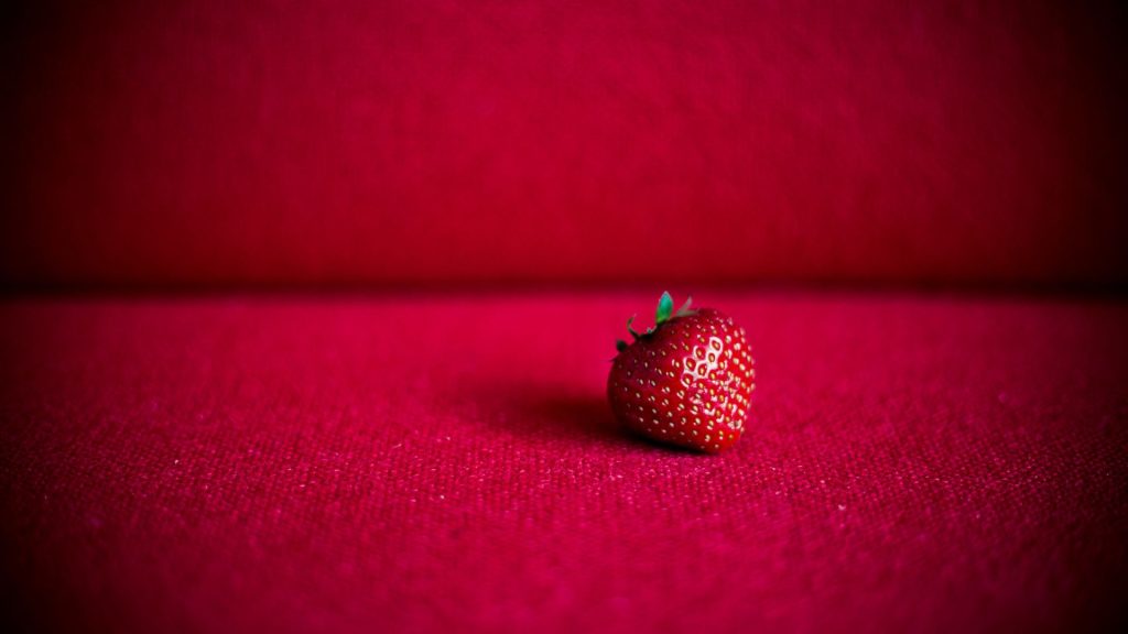 Cute little strawberry on red velvet background strawberry desktop wallpaper
