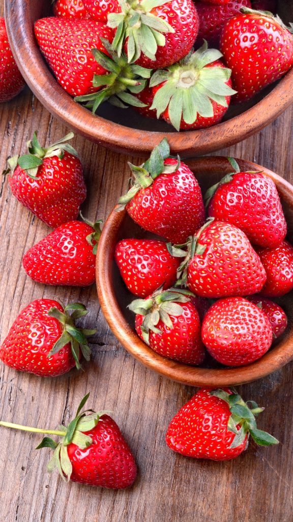 Strawberries in wooden bowls on wooden background strawberry phone wallpaper