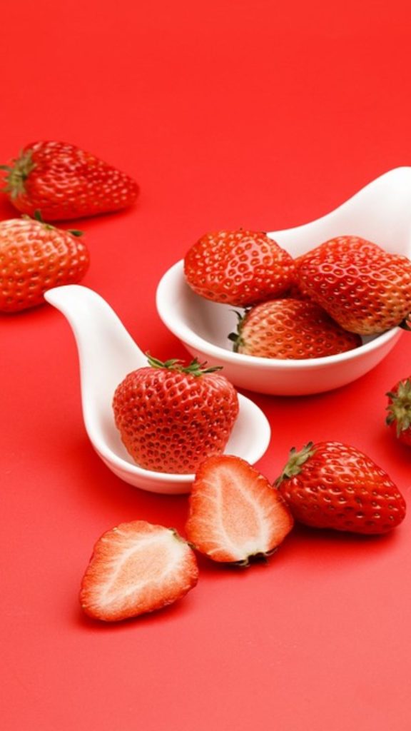 Strawberries with white mini bowl and reddish pink background strawberry phone wallpaper