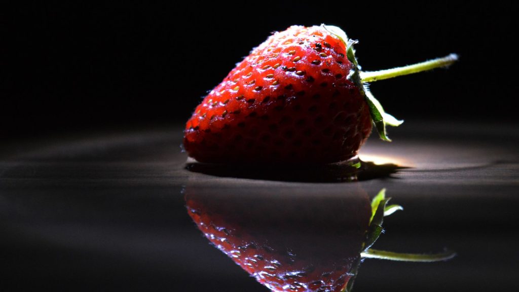 Strawberry zoomed photograph with black minimal background strawberry desktop wallpaper