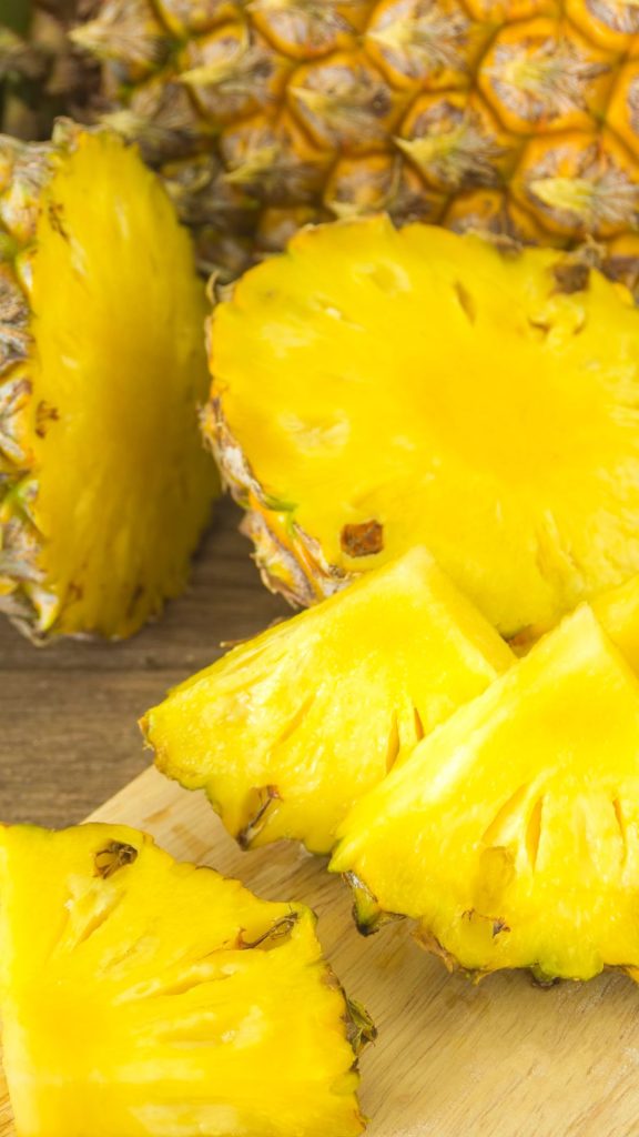 Fresh and sweet pineapple pieces on wooden table background Pineapple wallpaper