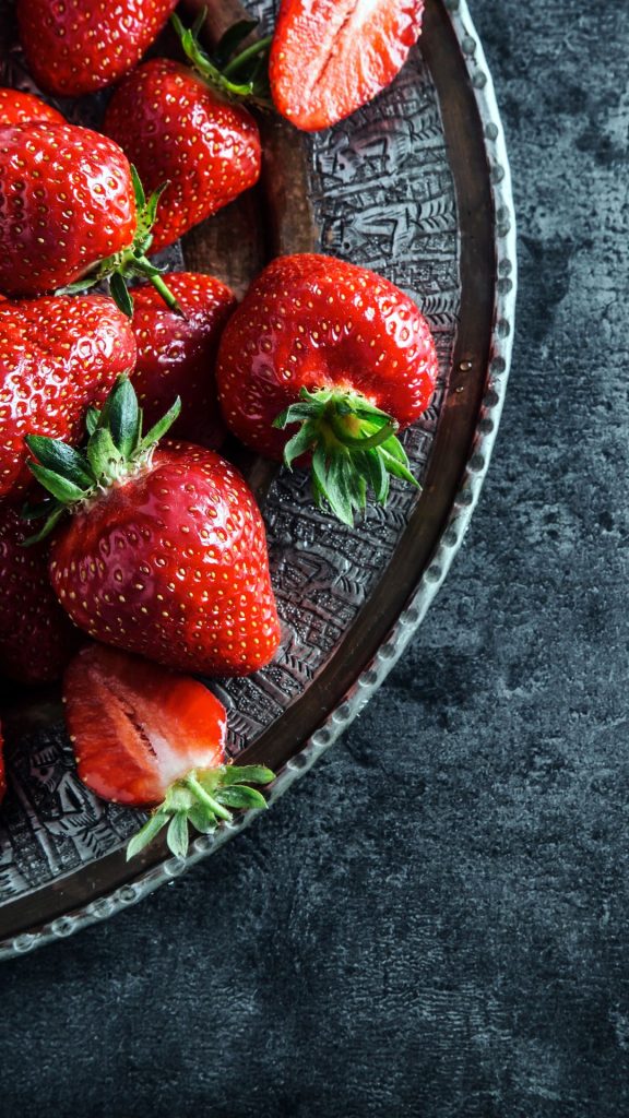 Fresh strawberries in glass bowl and grey framework Strawberry Background Wallpaper