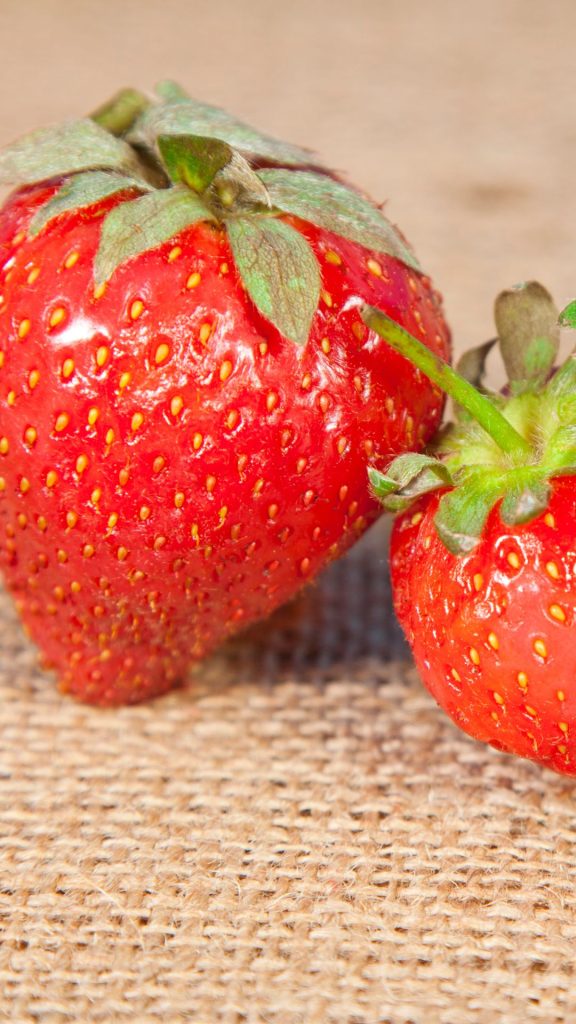 Red juicy strawberries on jute mat Strawberry Background Wallpaper