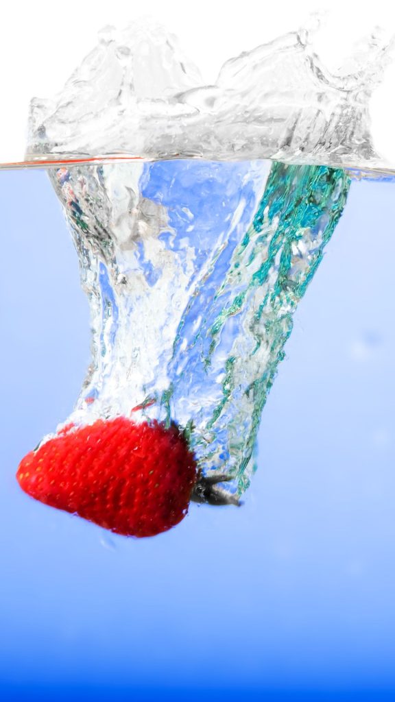 Red juicy strawberry splashing in water Strawberry Background Wallpaper