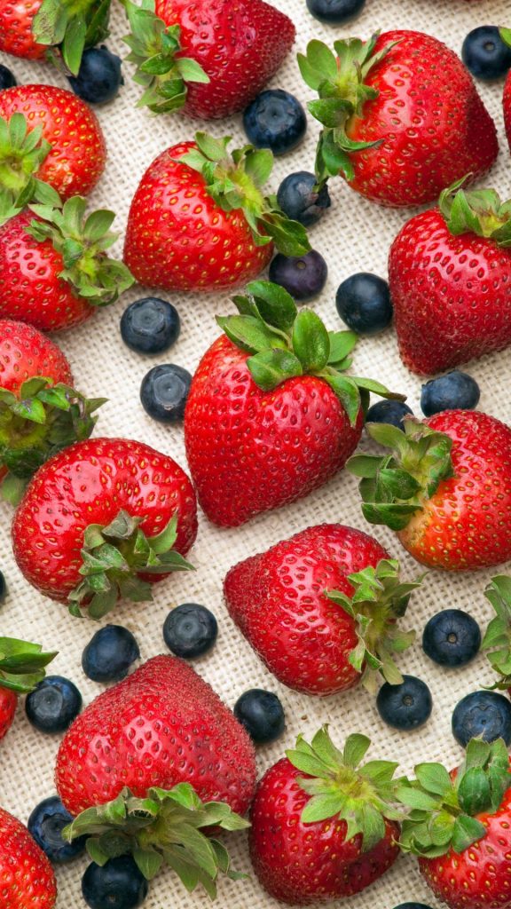 Strawberries and blueberries on white jute Strawberry Background Wallpaper