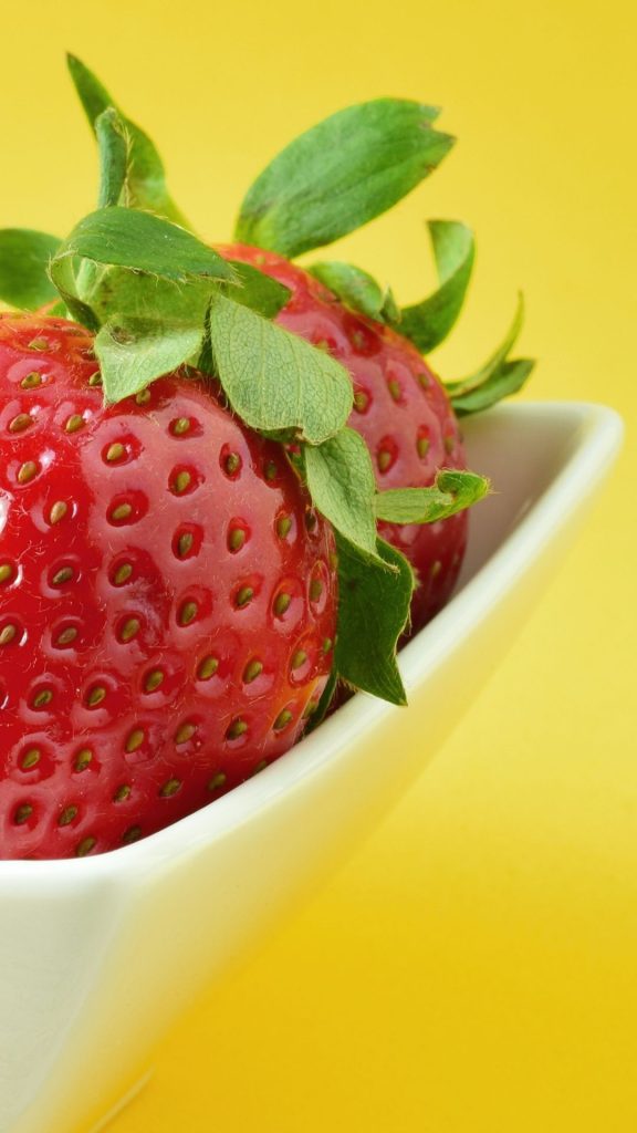 Strawberries in white bowl and yellow colour in the horizon Strawberry Background Wallpaper