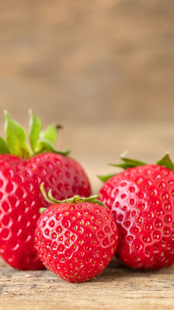 Strawberries on wooden surface with blurred horizon in the back Strawberry Background Wallpaper