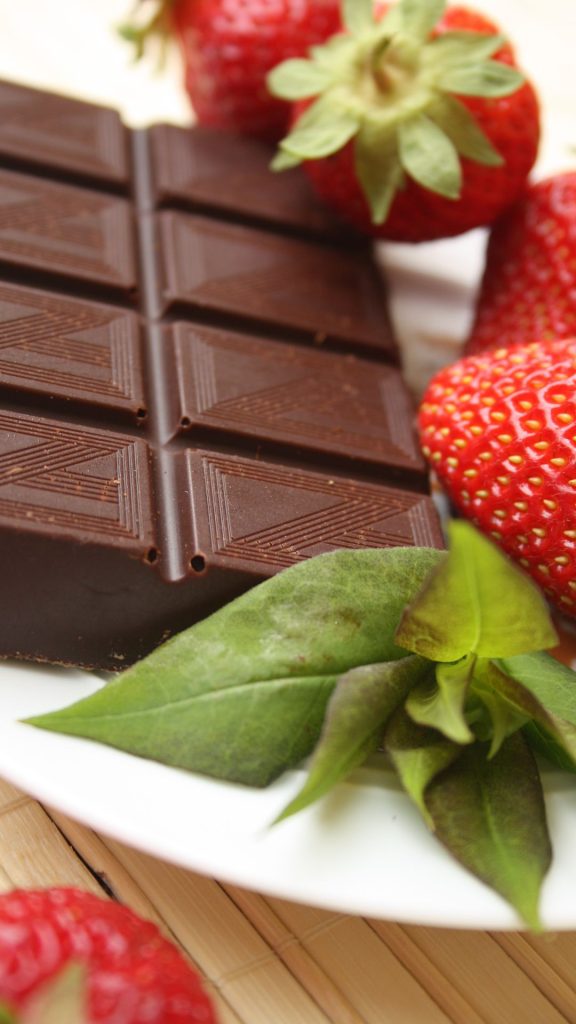Strawberries with green leaves and chocolate bar Strawberry Background Wallpaper