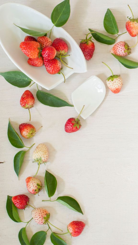 Strawberries with leaves in white bowl Strawberry Background Wallpaper