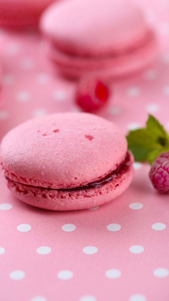Strawberry flavoured macaroon with strawberry jam on polka dots sheet pastel pink strawberry wallpaper
