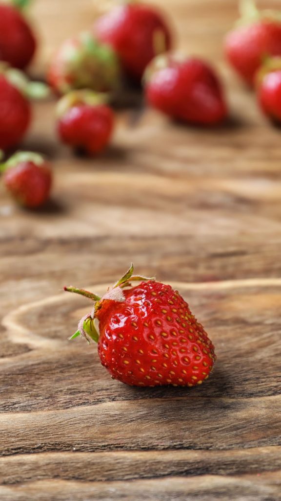 Strawberry on wood with blurred background Strawberry Background Wallpaper