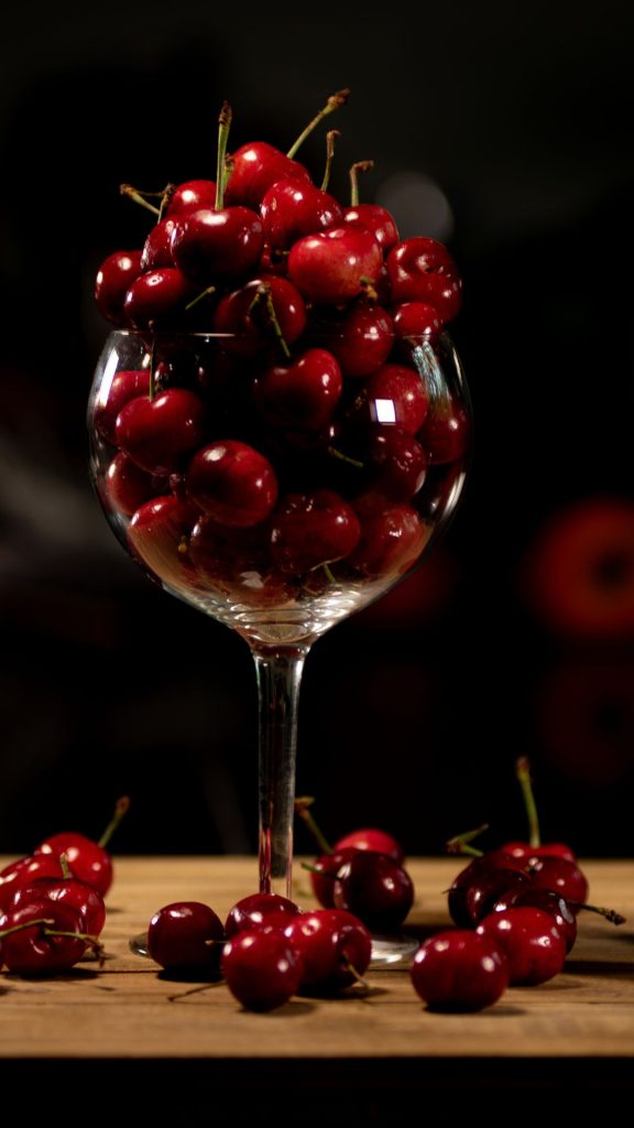 Vine glass filled with cherries with black background still cherry photograph aesthetic cherry wallpapers
