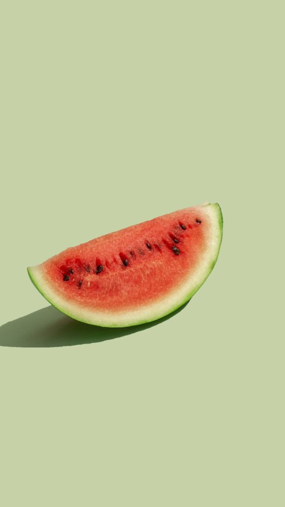 Aesthetic photo shoot of watermelon piece with green background watermelon wallpaper