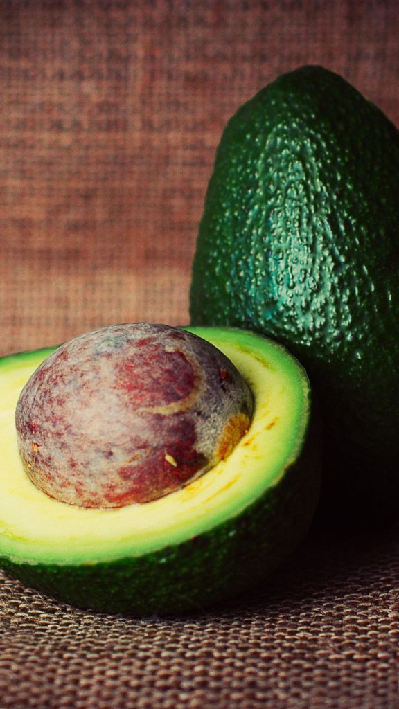Fresh avocado fruit with brown wooden background avocado wallpaper