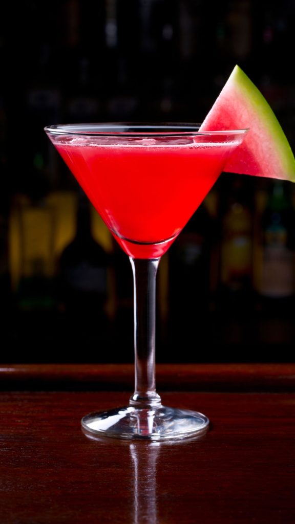 Red juice glass with watermelon piece and black background watermelon wallpaper