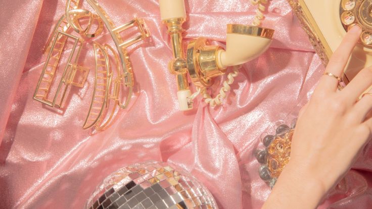 Gold telephone, disco ball, and pink silk collage, preppy wallpaper.