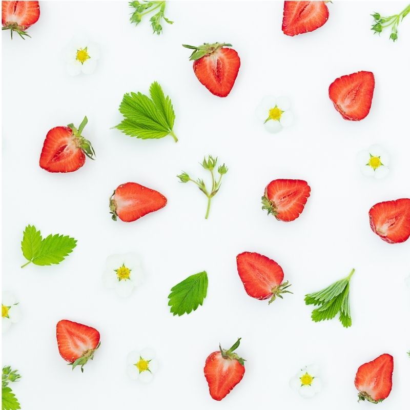 A pattern of coquette strawberries and green leaves on a white background